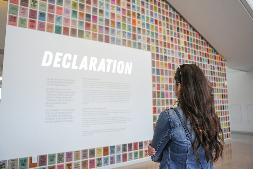 Photo: Woman standing in front of Declaration title wall