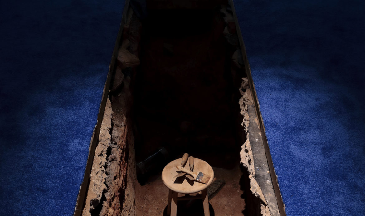 Two trenches appear in a darkened room with blue shag carpeting