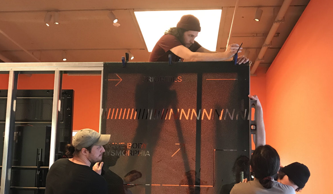 Lead preparator Andy Clifford puts the finishing touches on a piece for the Dialogues exhibition, February 2019.