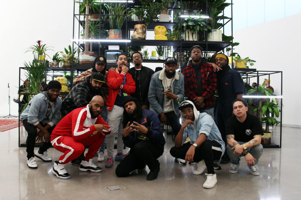 Members of the group "R V A Rap Elite" pose in front of Rashid Johnson's "Monument" exhibition.